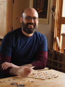 woodworker with glasses in front of workbench